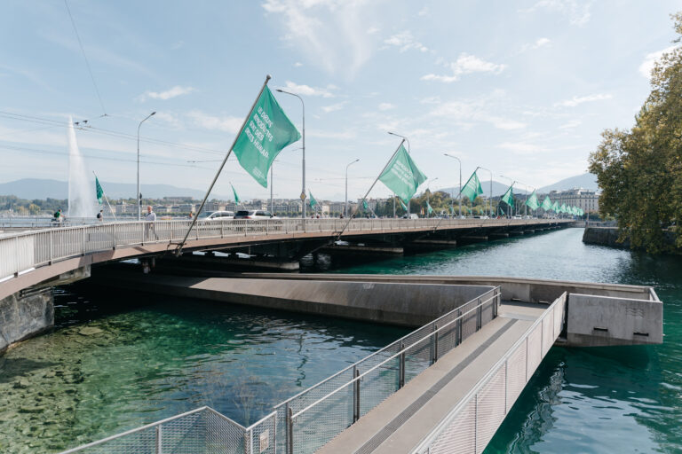 Pont du Mont-Blanc à Genève orné de drapeaux verts, avec le Jet d’eau au fond, le 28 septembre 2026